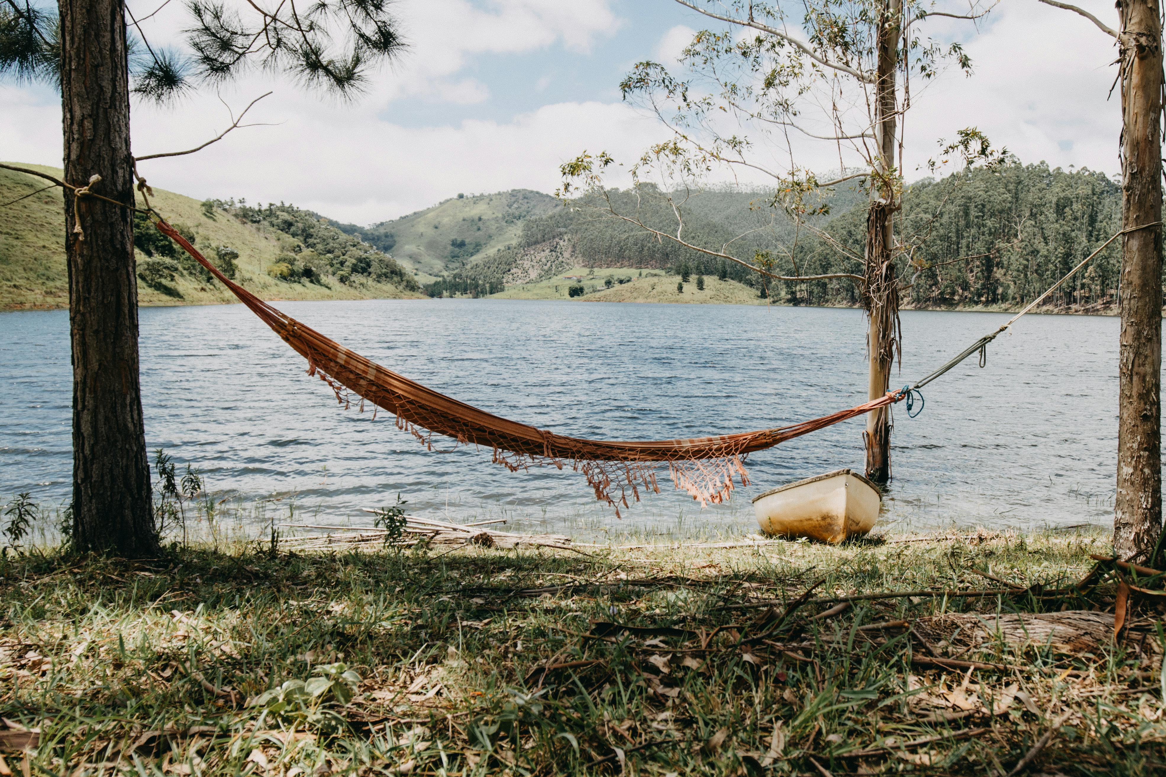 A lake in the background with a hammock and canoe by the shore